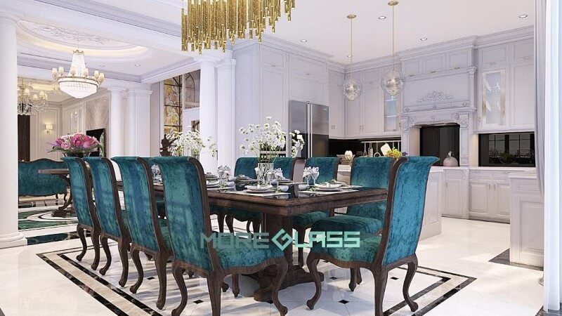 Thiết kế nội thất phòng bếp liền phòng ăn mang phong cách hoàng gia với màu trắng là chủ đạo. Điểm nhấn là bộ kính bếp màu đen huyền bí và bộ bàn ghế ăn màu xanh sang trọng. Thiết kế nội thất phòng bếp