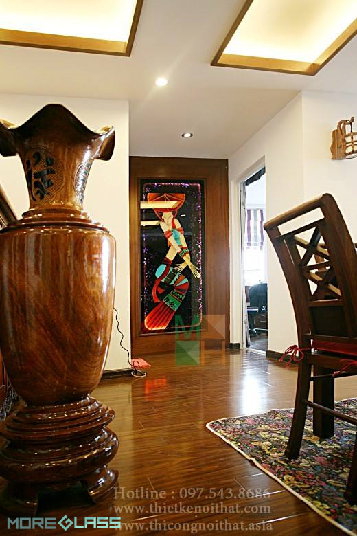 Mẫu tranh kính ốp tường tại chung cư Mễ Trì in nghệ thuật trừu tượng, góp phần cùng đồ nội thất gỗ óc chó tô điểm thêm vẻ đẹp tân cổ điển cho không gian ngôi nhà tranh kính
